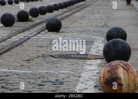 Disused tram tracks marked with iron balls along the sea wall of the marina in Santander short depth of field Cantabria Spain Stock Photo