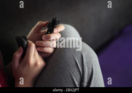 Cromwell, CT / USA - May 15, 2020: Young adult uses the Nintendo Switch's wireless Joy-Con controllers to game during the quarantine Stock Photo