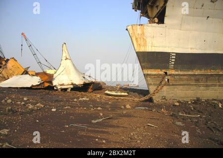 Shipbreaking Yard in Darukhana, Mumbai, India – INS Vikrant dismantling with scrap metal & workers in background Stock Photo