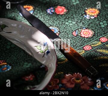 A simple but elegant tablecloth and cutlery laid out on it. Crystal glasses in the sun. Everything is ready for lunch in the garden.France. Stock Photo