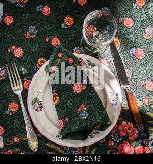 A simple but elegant tablecloth and cutlery laid out on it. Crystal glasses in the sun. Everything is ready for lunch in the garden.France. Stock Photo