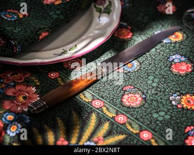 A simple but elegant tablecloth and cutlery laid out on it. Crystal glasses in the sun. Everything is ready for lunch in the garden.France. Stock Photo