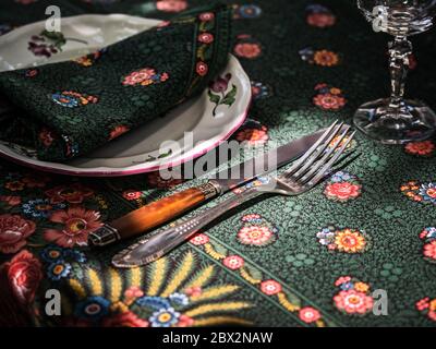 A simple but elegant tablecloth and cutlery laid out on it. Crystal glasses in the sun. Everything is ready for lunch in the garden.France. Stock Photo