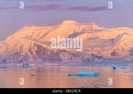 Antarctica, Southern Ocean, Antarctic Peninsula, polar cruise ship between icebergs at sunrise in the Gerlache Strait Stock Photo