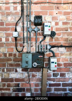Old collection of vintage electrical switches & controls on brick wall Stock Photo