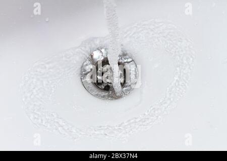 water falling in slow motion into the sink, drain closeup Stock Photo