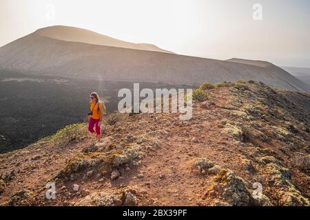 Spain, Canary islands, Lanzarote island, Los Volcanes Nature Park, hike to Montana Caldereta, on the edge of the crater, Caldera Blanca in the background Stock Photo