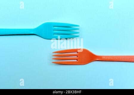 Two brightly colored forks facing towards each other on a ktchen table in retro style Stock Photo