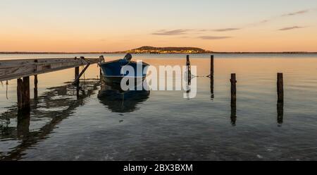 A boat moored on the Etang de Thau and at the bottom of Mont-Saint-Clair (Sète), in Hérault, in Occitanie, in the south of France Stock Photo