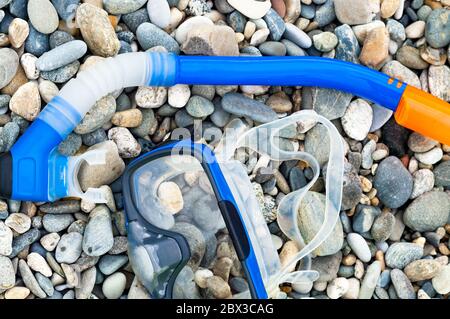 Blue snorkel and mask for diving on the pebble beach Stock Photo