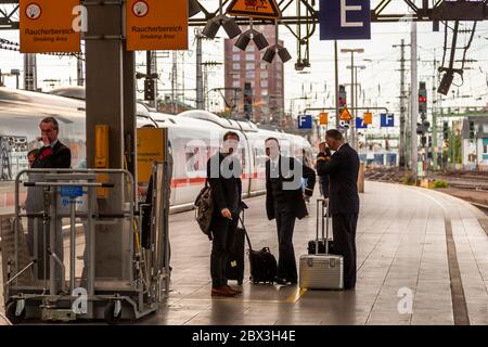 Train conductors at the end of the track in Cologne Central Station take a smoking break. Cologne Train Station, Germany Stock Photo