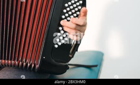 Young boy playing and practicing piano accordion. Stock Photo