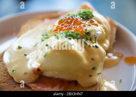 Eggs Benedict Royal, with smoked Salmon, poached eggs, Hollandaise sauce, Caviar and scallion, over a fresh brioche bread. Stock Photo