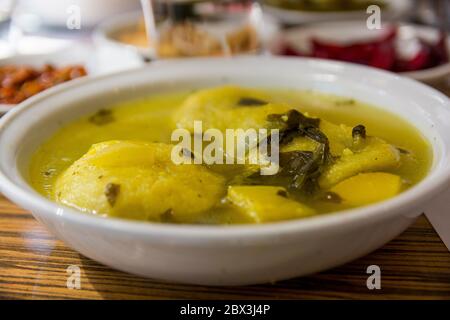 Traditional hot yellow Kubbe soup, a famous middle eastern dumplings soup dish, served in a bowl. Jerusalem, Israel. Stock Photo