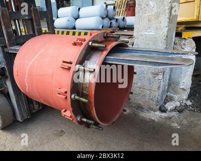 Red gland expansion joint for heating main on concrete floor. Heat and power concept. Stock Photo