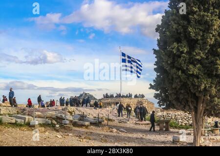 2018 01 03 Athens Greece - Tourists to the Acropolis in Athens gather around the Greek flag taking pictures with The Chapel of St. George on Lykavitto Stock Photo