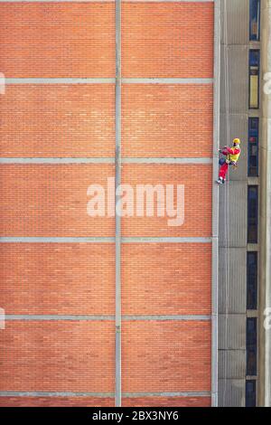 Construction workers are working in high building. For construction and repair brick facade. - Image Stock Photo