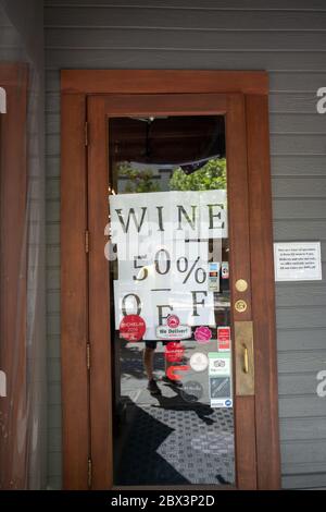 A homemade sign reads Wine 50% Off on a restaurant door in the Silicon Valley, Mountain View, California during an outbreak of the COVID-19 coronavirus, April 24, 2020. () Stock Photo