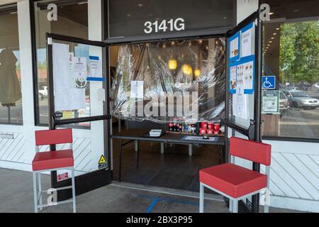 A plastic sheet is used to block the door of a restaurant which is accepting to go orders only during an outbreak of the COVID-19 coronavirus in San Ramon, California, April 25, 2020. () Stock Photo