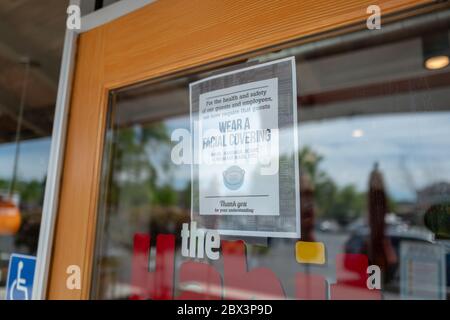 A sign at a restaurant in San Ramon, California warns visitors to wear a face covering or face mask before entering during an outbreak of the COVID-19 coronavirus, April 25, 2020. () Stock Photo