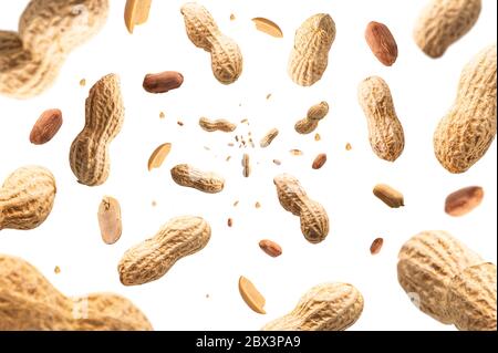 Collection of peanuts falling isolated on white background. Selective focus Stock Photo
