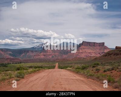 A straight gravel road with beautiful mountain scenery in the background Stock Photo