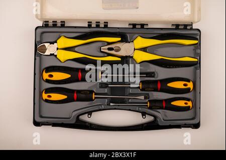 Various screwdrivers and pliers in a plastic case. Close up. Manual locksmith and installation tools for home work Stock Photo