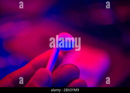 white wireless earbud for smartphone in hand. Relaxation concept. Stock Photo
