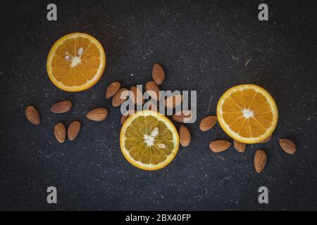 Oranges and almonds in a dark background Stock Photo