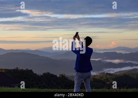 Unidentified man are capturing picture using smart phone-Travel Concept Stock Photo