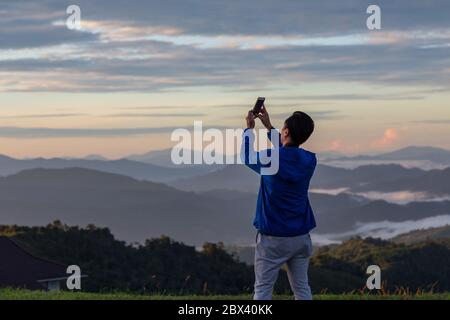Unidentified man are capturing picture using smart phone-Travel Concept Stock Photo