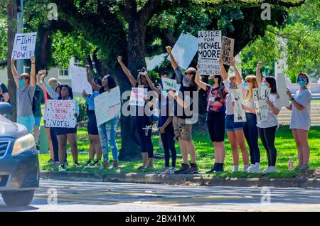 Protestors wave signs while at a protest against police brutality, June 4, 2020, at Memorial Park in Mobile, Alabama.