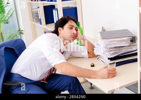 Young businessman employee drinking in office Stock Photo