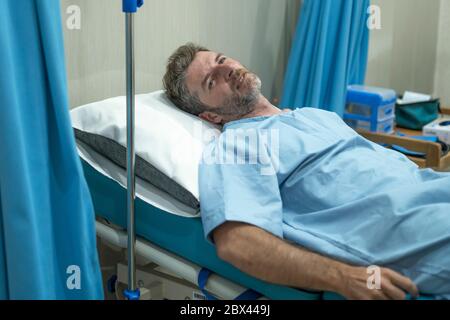 scared and worried man in pain at hospital room - attractive injured man lying on bed suffering painful problem feeling sick and stressed after suffer