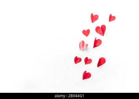 Flying red paper hearts on white background. Valentine's Day. Symbol of love. Copy space. Stock Photo