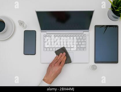 Sanitizing laptop in office Stock Photo