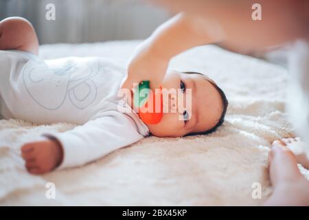 baby child lying on belly weared diaper with teether Stock Photo