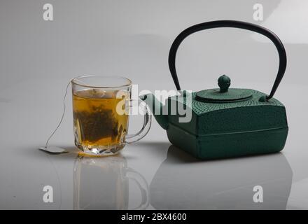 a green teapot and a cup of green tea Stock Photo