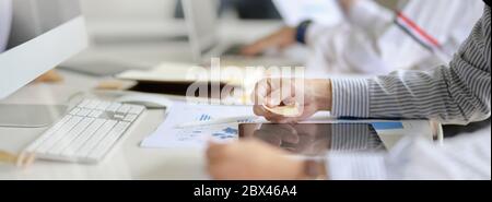 Side view of UI developer looking information on digital tablet while working on white worktable Stock Photo