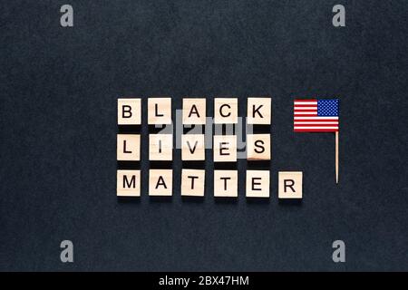 Black lives matter inscription on a black background. unrest. hashtag Blacklivesmatter. protests. American flag. USA Stock Photo