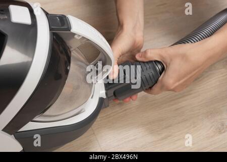 woman woman takes apart modern cyclone bagless vacuum cleaner. housekeeping, cleaning. Stock Photo