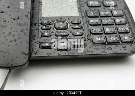 Button of desktop touch telephone covered with waterdrops on white table. Retro, dialing, connection, communication. Russia, Bashkortostan, July 2019. Stock Photo