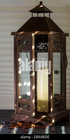 open wooden lantern shining on the sun's rays, with candle and coffee beans as decoration Stock Photo