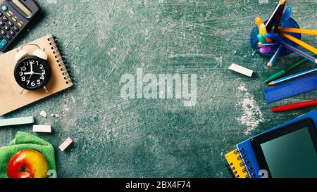 Concept back to school on schedule. alarm clock, notebooks, pencils, student or student tools on Green Blackboard Background for chalk. top view Stock Photo
