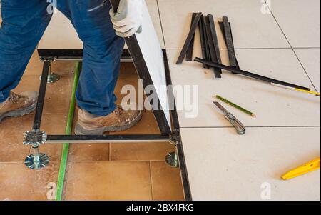 Worker working Raised floor in modern interior of server room in datacenter. Stock Photo