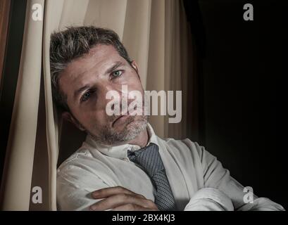 dramatic lifestyle portrait of young sad and depressed businessman in necktie feeling frustrated suffering depression and business problem leaning on Stock Photo