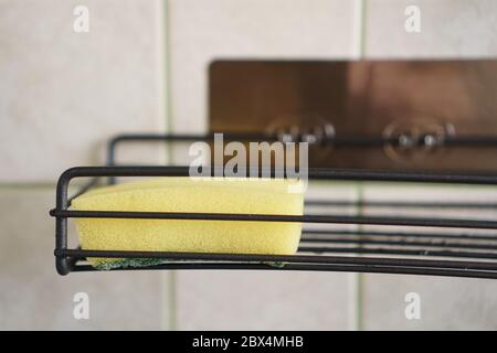 Sponge for washing dishes on metal shelf in kitchen. Concept of cleaning. Close-up interior. No people. Stock Photo
