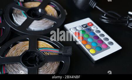Led strip coils closeup. Diode with control panel for switching colors on dark background. Stock Photo