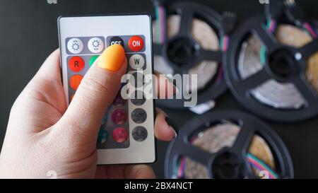 Remote control for change colors in hand on blurred background with led light Stock Photo
