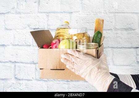Donation of food collected in a box. Gray background. Copy space Stock Photo